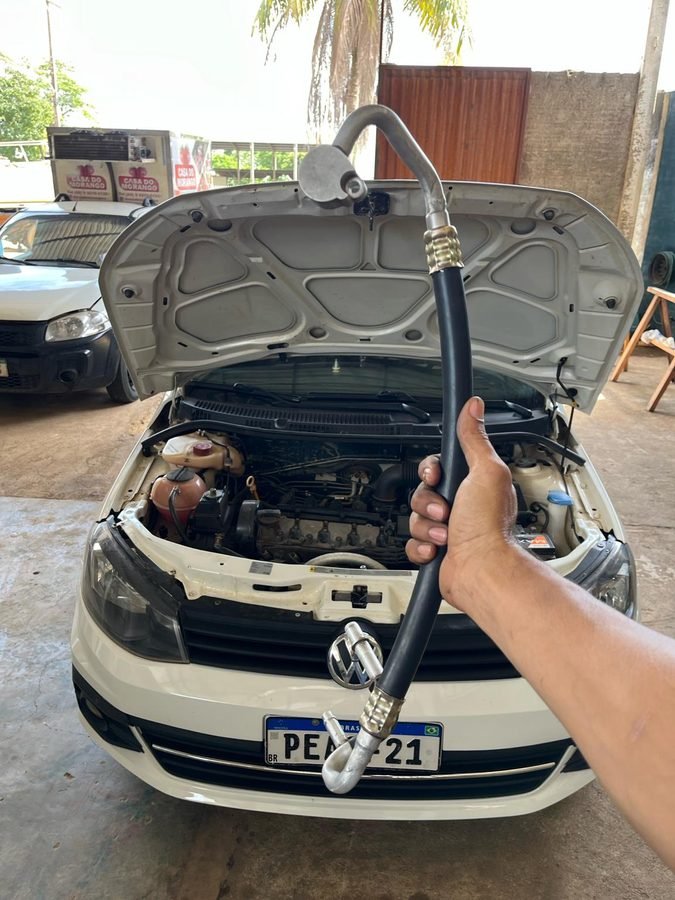 Técnico segurando mangueira do sistema de ar-condicionado